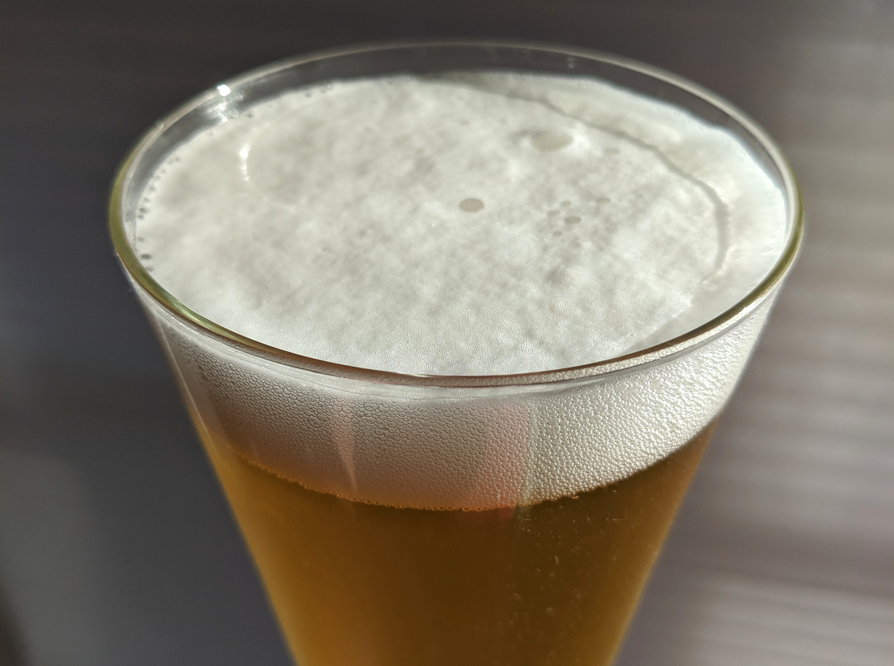 Close-up of pilsner beer foam in conical glass