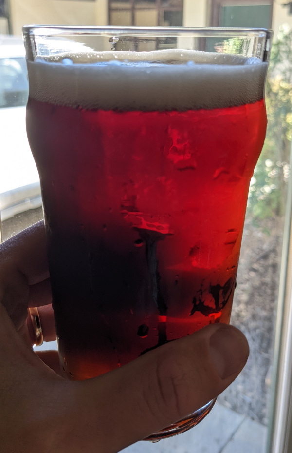 reddish amber colored beer in English pint glass